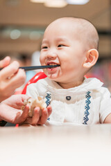 A baby boy in a dining chair in a dining room