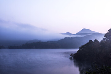 Beautiful autumn scenery, water mist over the lake and sea clouds on the mountain at dawn.