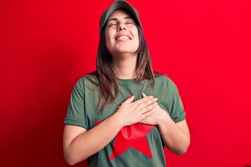 Young beautiful brunette woman wearing cap and t-shirt with red star communist symbol smiling with...
