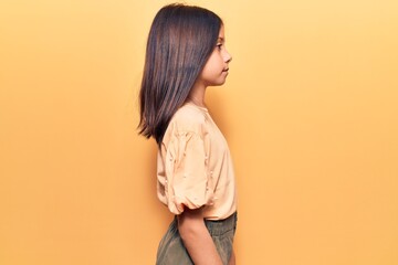 Beautiful child girl wearing casual clothes looking to side, relax profile pose with natural face...