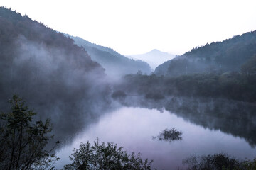 Beautiful autumn scenery, water mist over the lake and sea clouds on the mountain at dawn.
