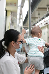 Fototapeta premium Asian mothers take their children on the subway
