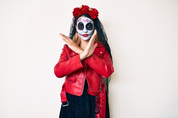 Woman wearing day of the dead costume over white rejection expression crossing arms doing negative sign, angry face