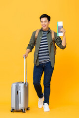 Young handsome Asian tourist man with luggage passport and boarding pass ready to go for travel on...