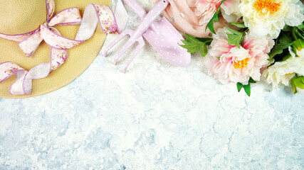 Spring theme, peonies and sunhat desktop workspace with gardening tools on stylish white marble textured background. Top view blog hero header creative composition flat lay.