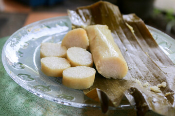 Fototapeta na wymiar Close up photo of rice cake or commonly called lontong, traditional food wrapped in banana leaf from central java indonesia on a plate