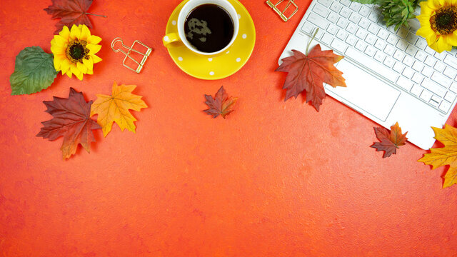 Autumn Fall Halloween Thanksgiving theme desktop workspace with laptop on stylish orange textured background. Top view blog hero header creative composition flat lay.