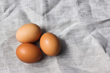 Three farm eggs on a linen napkin