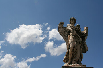 Fototapeta na wymiar statue of angel with garment and dice in blue sky background