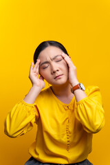 Asian woman was sick with headache isolated on yellow background.