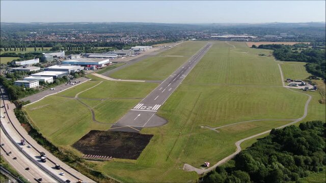 Southampton International Airport Runway aerial orbit drone shot. UK flights, transportation. COVID-19 means lack of flights, quiet. Flybe job losses.Motorway, M27
