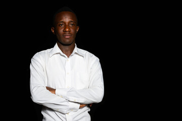 Young African businessman in the dark against black background