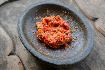 Fresh sambal served on stone mortar (cobek). Sambal is traditional sauce from indonesia made from chili.
