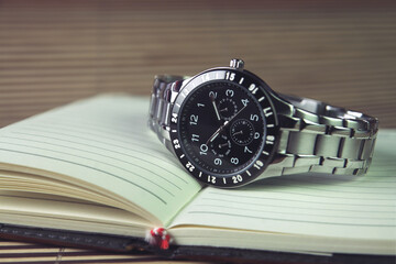 Men's wrist watch on Notebook or Business Planner