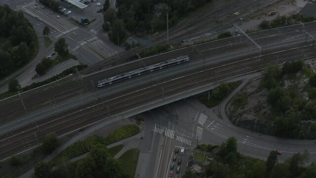 Aerial drone shot of train and railways on a bridge over road.