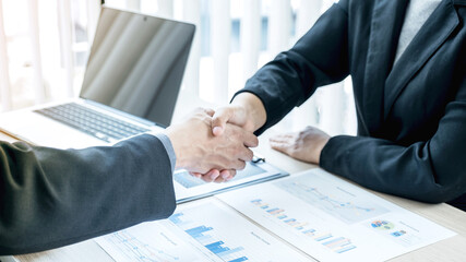 businessmen and businesswomen shacking hands after meeting to plan strategies to increase business income. Have a brainstorming graph analysis and discussing for the new target success