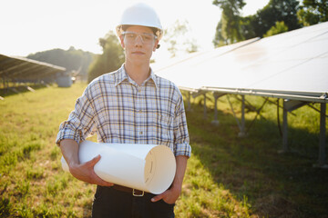 Installing and wiring of stand-alone solar photo voltaic panel system. Close-up of young electrician in hard-hat. Alternative energy concept.