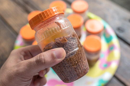 Holding Bagoong in plastic containers for sale. Small business opportunity in Philippines. Bagoong is made of either fermented fish or krill or shrimp paste with salt.