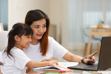 Fototapeta premium Happy family. Mother and daughter together paint. Adult woman helps the child girl.