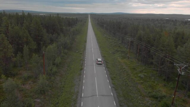 Drone following a silver volvo in northern Swedish landscape