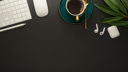 Workplace with copy space, digital accessories, coffee cup and leaf decorated on black table