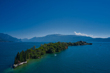 Aerial view of the island Garda, Lake Garda, Italy. Is the biggest island on Lake Garda. In the background Alps, blue sky.