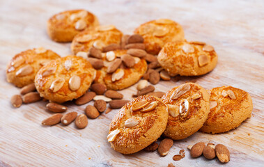 Sweet shortbread cookies with almond nuts on wooden background