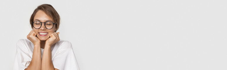 Fototapeta premium Monochrome photo of a caucasian woman with eyeglasses waiting for a present on a white studio wall with free space