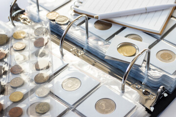 Different old collector's coins with a magnifying glass
