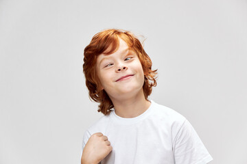 Portrait of red-haired child grimacing white t-shirt fun studio
