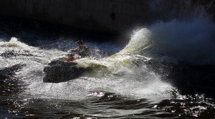 The jet ski is in motion along with the wave and spray