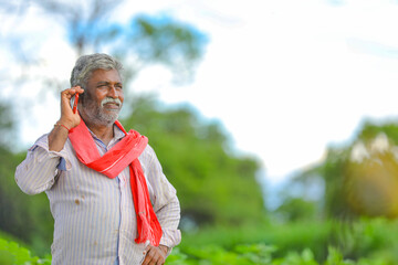 Indian farmer talking mobile phone at Agriculture field