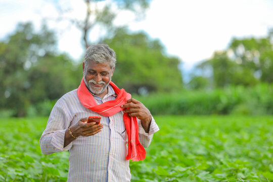 Indian Farmer Using Mobile Phone At Agriculture Field