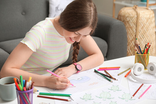 Young woman coloring picture at home