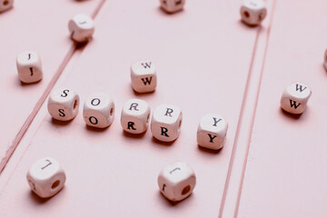 Cubes with word SORRY on table