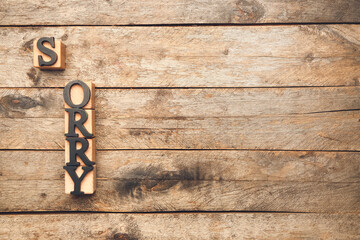 Cubes with word SORRY on wooden background