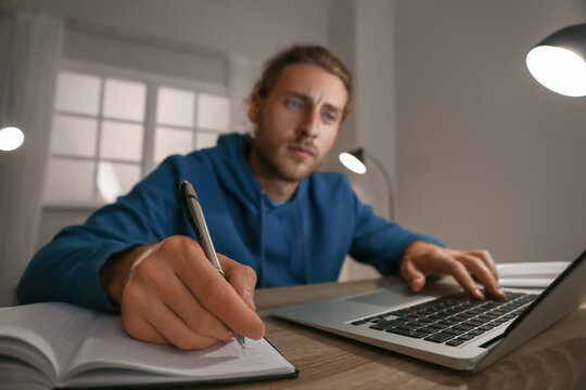 Young man using laptop for online learning at home