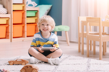 Cute little boy with tablet computer at home