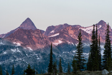 Mountain range at the sunset, rocky mountains, Valhalla Provincial Park, West Kootenays, BC, Canada. Pink an dred undertones, dramatic