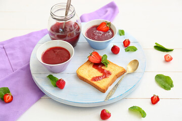 Sweet strawberry jam and toasted bread on table