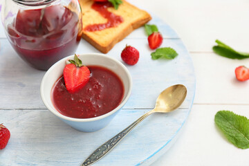 Sweet strawberry jam and toasted bread on table