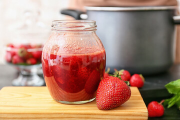 Sweet strawberry jam in jar on table