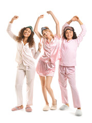 Obraz premium Beautiful young women in pajamas and with sleep masks on white background