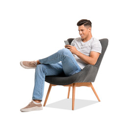 Young man with mobile phone relaxing in armchair on white background