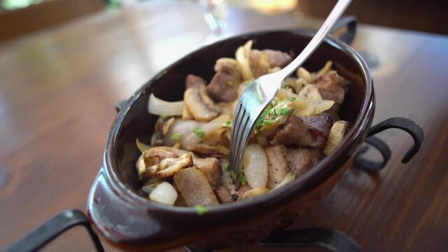 POV Eating Meat Dish on Ketsi in Restaurant. Chashushuli. Hot Meat in Clay Pan on Table