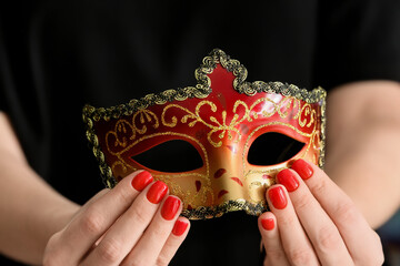 Woman with beautiful manicure holding mask, closeup