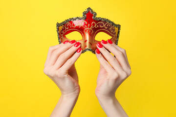 Hands with beautiful manicure holding mask on color background