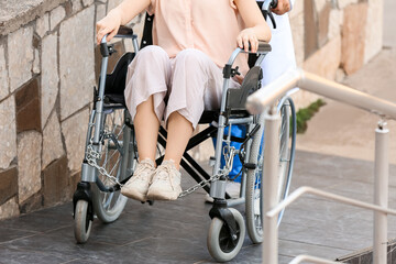 Obraz premium Doctor and young woman in wheelchair on ramp outdoors