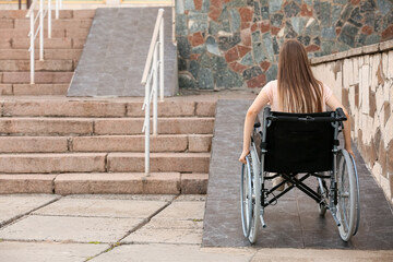 Young woman in wheelchair on ramp outdoors