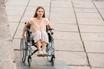 Young woman in wheelchair on ramp outdoors